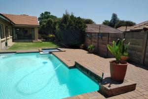 a large swimming pool in a yard with a fence at Catch your Breath in Edenvale