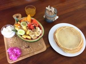 a table with a bowl of fruit and a plate of food at Weligama Ocean Breeze in Weligama
