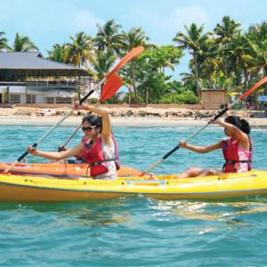 three people are in a kayak in the water at Cherai Ocean View Home in Cherai Beach