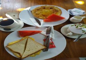 two plates of food on a wooden table at Pondok Krishna in Kuta