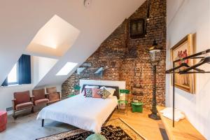 a bedroom with a bed and a brick wall at BareFoodGIULIA in Hasselt