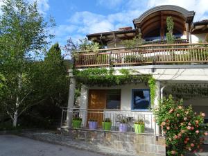 a house with a balcony and potted plants on it at Alpapart - Innsbruck in Ellbögen