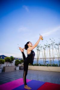 a woman is doing a yoga pose on a mat at Marilyn Boutique Hotel Nha Trang in Nha Trang