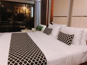 - un grand lit blanc avec des oreillers en noir et blanc dans l'établissement Phi Phi Ton Sai Place, sur les Îles Phi Phi