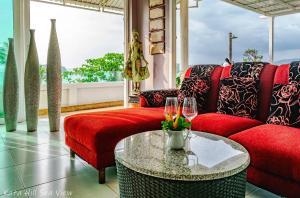 a living room with a red couch and a table at Hotel Kata Hill Sea View in Kata Beach