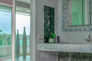 a bathroom with a sink and a mirror and a window at Hotel Kata Hill Sea View in Kata Beach