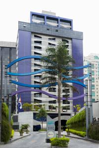 un edificio alto con un árbol delante de él en Address São Paulo Faria Lima by Intercity, en São Paulo