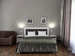 um quarto com uma cama, uma cadeira e um sofá em Hotel Abaata em Gagra