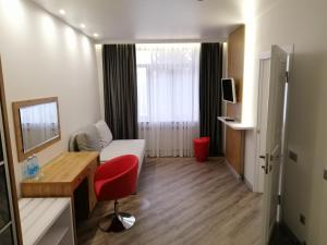 a small room with a red chair and a desk at Гостинний Двір in Bar