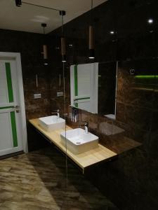 Baño con 2 lavabos y espejo en Гостинний Двір, en Bar