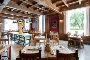 a restaurant with wooden tables and chairs and a large window at New Peterhof Hotel in Petergof