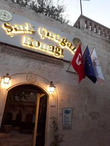 a building with a sign and two flags on it at ŞarkÇırağan Konak Boutique Hotel in Urfa