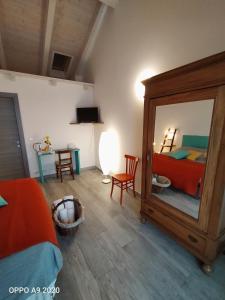 1 dormitorio con espejo, cama y mesa en B&B Madonna degli Airali en Vezza d'Alba