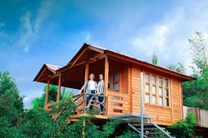 two people standing on the balcony of a tiny house at Woodgreens Heritage Resorts in Kannur