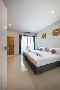a bedroom with two beds and a door to a bathroom at May House Karon Beach in Karon Beach