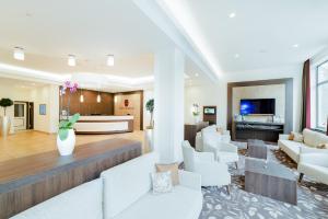 a living room with white furniture and a fireplace at Hotel Seeblick in Bernried