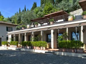 un bâtiment avec des plantes en pot sur son côté dans l'établissement FH55 Hotel Villa Fiesole, à Fiesole