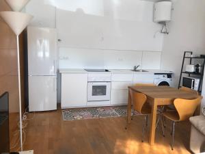 a kitchen with a wooden table and a white refrigerator at Estudio acogedor renfe in Alicante