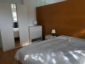 1 dormitorio con 1 cama blanca grande y espejo en Estudio acogedor renfe, en Alicante