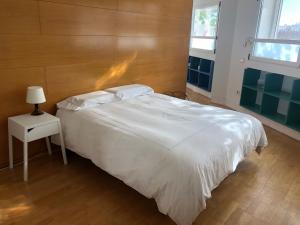 1 dormitorio con 1 cama blanca grande y mesita de noche en Estudio acogedor renfe, en Alicante