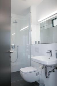 a white bathroom with a toilet and a sink at Stadtrandzimmer in Herrnburg