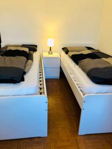 TassulloにあるLa Casa di Olivoのベッド2台が隣同士に設置された部屋です。