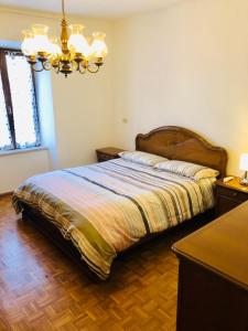 1 dormitorio con cama y lámpara de araña en La Casa di Olivo, en Tassullo