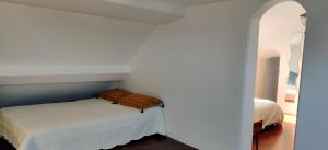 - une chambre avec un lit dans un mur blanc dans l'établissement Charmant 2 pièces à quelques minutes de Disneyland., à Lagny-sur-Marne
