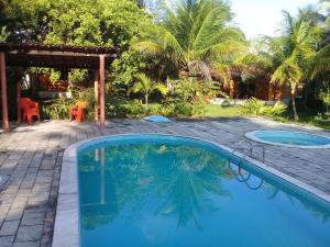 a swimming pool in front of a house with a patio at Sitio da Calma in Gamela