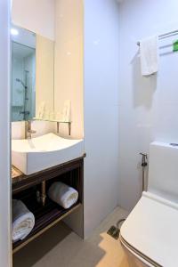 a bathroom with a sink and a toilet and a mirror at Hamersons Hotel in Cebu City