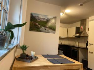 a kitchen with a table with a picture on the wall at Anton‘s Souterrain-Wohnung in Eberfing