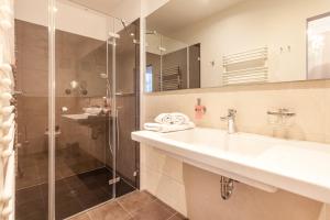 a bathroom with a sink and a shower at Hotel Vier Jahreszeiten Binz - Adults Only in Binz