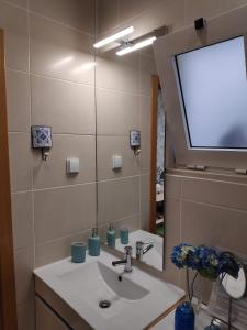 La salle de bains est pourvue d'un lavabo et d'un grand miroir. dans l'établissement The Sunny Cottage, à Faro
