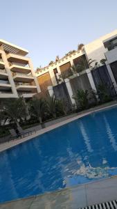 uma grande piscina azul em frente a um edifício em Sheraton ocean 401 no Cairo