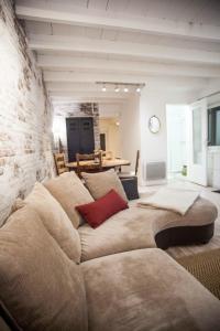 ein großes Sofa in einem Zimmer mit Ziegelwand in der Unterkunft Les 2 C’ in Cayeux-sur-Mer