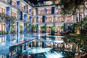 uma piscina de hotel em frente a um edifício em Sakmut Boutique Hotel em Siem Reap