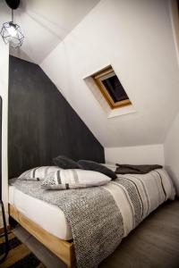 a bedroom with a bed with a black accent wall at Les 2 C’ in Cayeux-sur-Mer