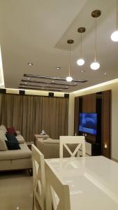 Sheraton ocean 401 في القاهرة: غرفة معيشة مع طاولة وأريكة وتلفزيون