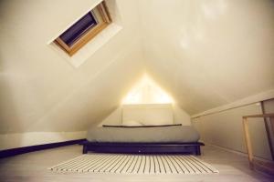 a bedroom with a bed in a attic with a window at Les 2 C’ in Cayeux-sur-Mer