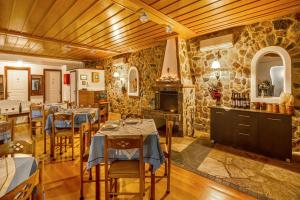 um restaurante com mesas e cadeiras e uma parede de pedra em Hotel PARALIAKO Kyparissi em Kyparissia