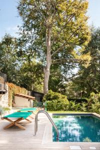 a swimming pool in a yard with a tree at Il Lavatoio in Cissano