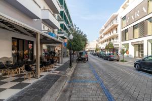 a cobblestone street in a city with parked cars at N E P center Hotel Rodos in Rhodes Town