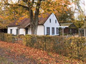 a white house with a tree and a fence at Acacia 1 Hengelhoef in Aan de Wolfsberg