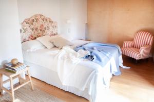 1 dormitorio con 1 cama blanca y 1 silla en Il Lavatoio, en Cissano