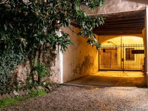 einen Eingang zu einem Gebäude mit einem Tor und einem Baum in der Unterkunft Corte La Nespola in Pescantina