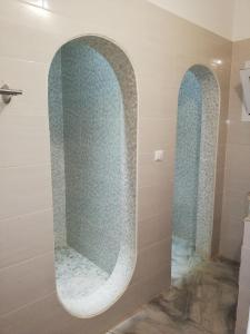 ein Badezimmer mit einer Dusche und zwei Torbögen in der Unterkunft Villa Roka - Toubab Dialaw in Toubab Dialao