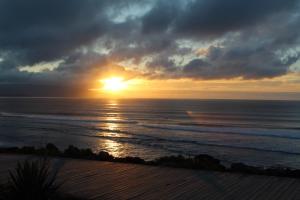 einen Sonnenuntergang über dem Meer mit Sonnenuntergang in der Unterkunft Casa da Levada in Ribeira Grande