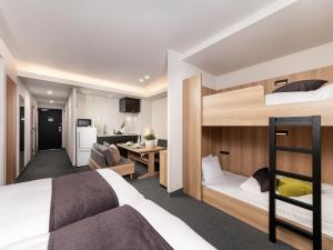 a bedroom with two bunk beds and a kitchen at MIMARU Tokyo Ginza East in Tokyo