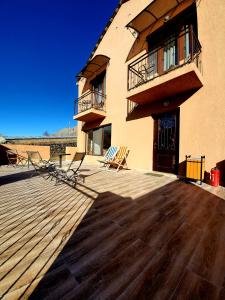 a building with chairs sitting on a wooden deck at Nikolo Inn in Stepantsminda