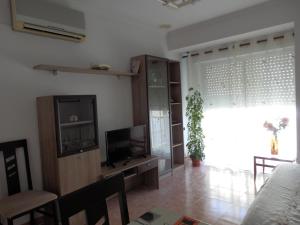a living room with a flat screen tv and a table at Apartamento funcional y acogedor in L'Ametlla de Mar